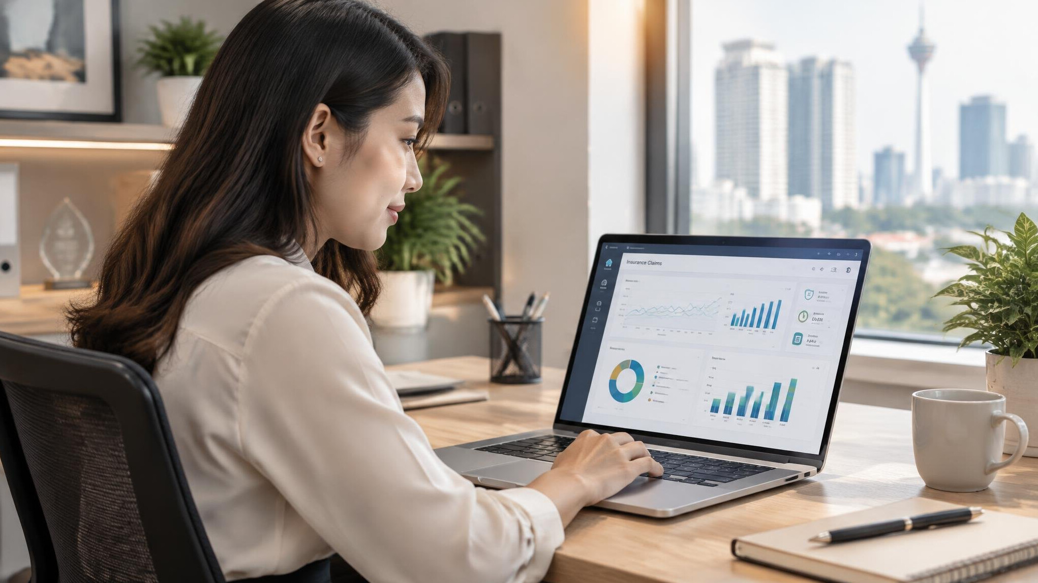 Malaysian Chinese woman analyzing data dashboards on a laptop in a modern office