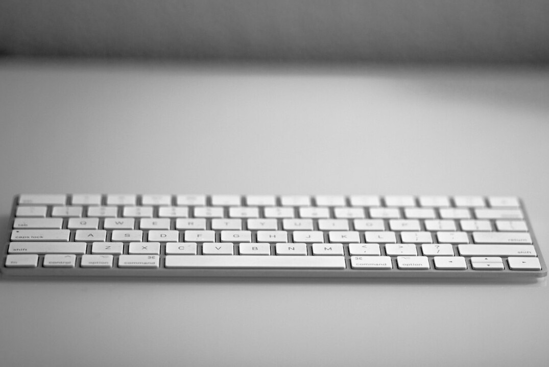 Close-up of hands typing on a laptop keyboard with a data chart visible on screen